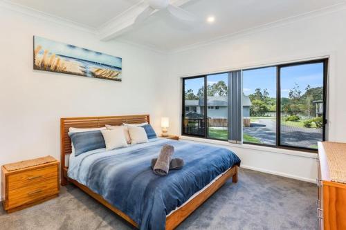 a bedroom with a bed and a large window at The Fig in Mylestom