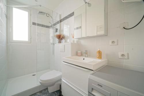 une salle de bain blanche avec un lavabo et des toilettes dans l'établissement Ravissant cocon moderne - proche Stade de France, à Saint-Denis