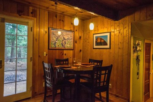 Un comedor de madera con mesa y sillas. en Cozy Yosemite Cabin with Hot Tub in the Pines, en Fish Camp