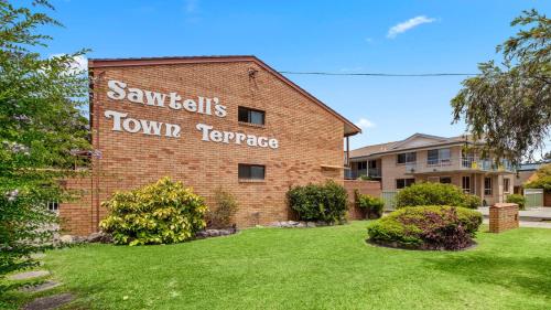 a brick building with a sign that reads santilli town korea at Town Terrace 8 in Sawtell