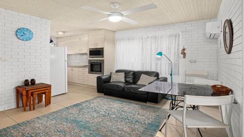 a living room with a black couch and a table at Town Terrace 8 in Sawtell