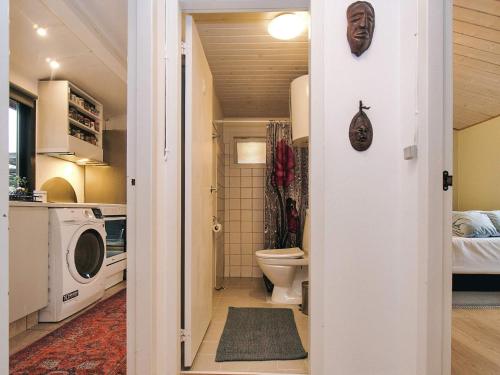 a bathroom with a toilet and a washer and dryer at 8 person holiday home in Holbæk in Holbæk