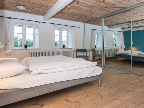 a large bed in a room with windows at 4 star holiday home in Højer in Højer