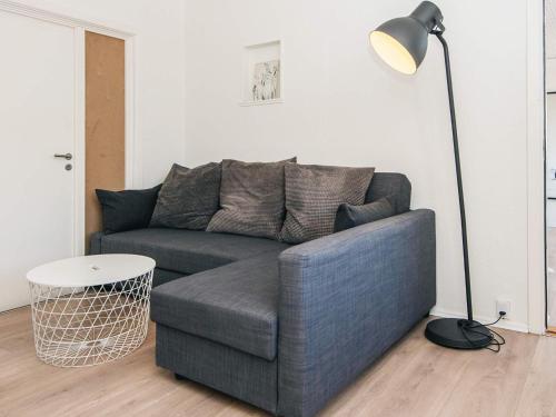 a living room with a blue couch and a lamp at 6 person holiday home in Ringkøbing in Ringkøbing