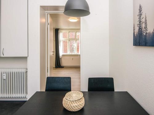 a dining room with a black table and two chairs at 6 person holiday home in Ringkøbing in Ringkøbing
