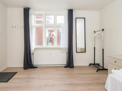 a bedroom with black curtains and a window at 6 person holiday home in Ringkøbing in Ringkøbing