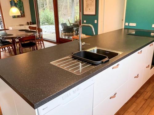 a kitchen counter with a sink and a table at 6 person holiday home in Asperup in Asperup