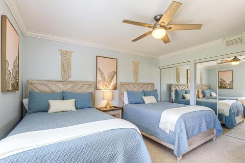 a bedroom with two beds and a ceiling fan at Luxe Fort Pierce Beach Condo with Golf Views! in Fort Pierce