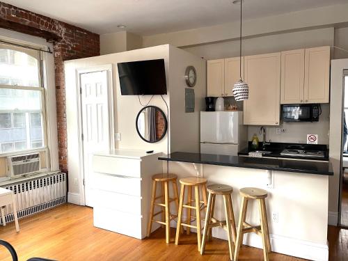 a kitchen with white cabinets and bar stools at Nest aparthotel with kitchenette in New York