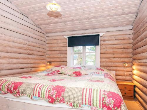 a bedroom with a bed in a log cabin at 4 star holiday home in Fårvang in Fårvang