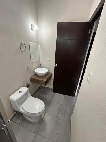 ein Badezimmer mit einer weißen Toilette und einem Waschbecken in der Unterkunft Casa Punta del Este Paraiso Tabasco in Paraíso