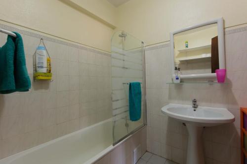uma casa de banho com um lavatório e um chuveiro com um espelho. em Enjoy the Ria Formosa Estuary em Faro