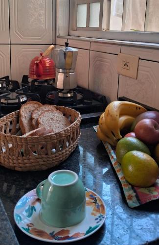 un comptoir avec une assiette de pain et une corbeille de fruits dans l'établissement Casa simples, à Tremembé