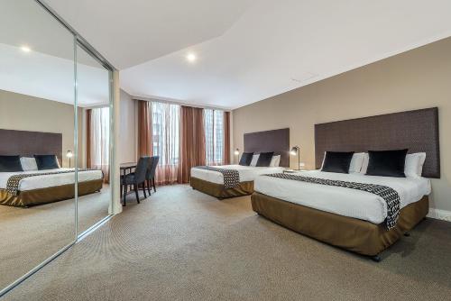 墨爾本的住宿－小柏克街曼特拉酒店，酒店客房配有两张床和一张书桌
