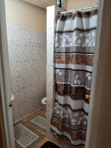 a shower curtain in a bathroom with a toilet at Ingos comfort place in Roseau