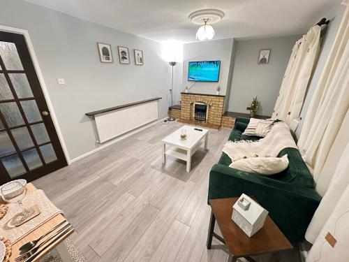 a living room with a couch and a tv at Spacious Luton Airport Accommodation - Perfect for Contractors, Families, Tourists & Long Stays in Luton