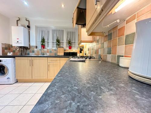 a large kitchen with a large counter top at Spacious Luton Airport Accommodation - Perfect for Contractors, Families, Tourists & Long Stays in Luton