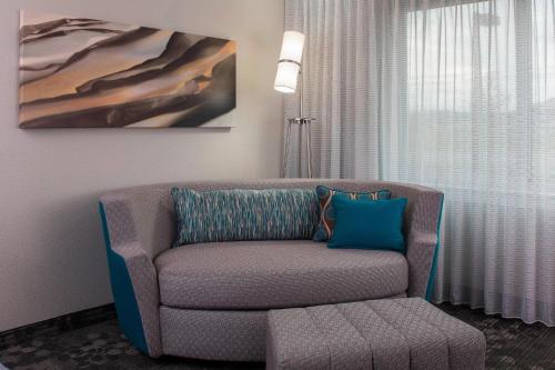 a living room with a chair and a painting at Courtyard by Marriott Nashville Goodlettsville in Goodlettsville