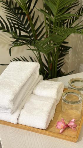 a wooden cutting board with towels and a glass of water and flowers at Gelis Gede Cottages in Uluwatu