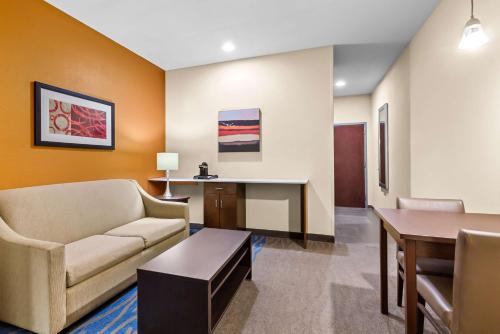 a living room with a couch and a table at Best Western St. Louis Airport North Hotel & Suites in Hazelwood