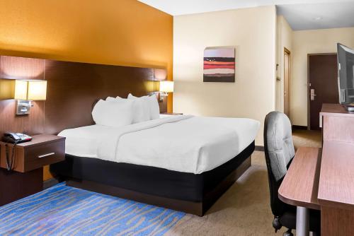 a hotel room with a large bed and a desk at Best Western St. Louis Airport North Hotel & Suites in Hazelwood