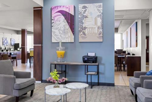 a lobby with a waiting area with chairs and tables at Best Western St. Louis Airport North Hotel & Suites in Hazelwood