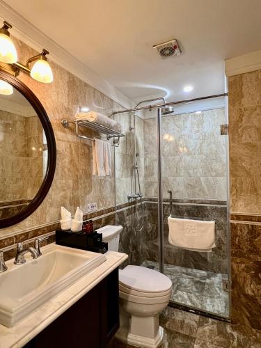 a bathroom with a toilet and a sink and a shower at Hotel du Monde in Hanoi