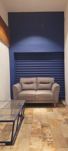 a living room with a couch and a blue wall at Luna Azul in Tapachula