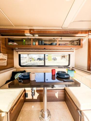 a small kitchen with a table in a caravan at Navi- HUGE yard- MEGA playset- CUTE RV in Willmar