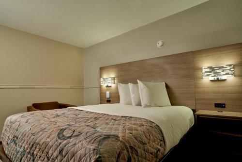 a hotel room with a large bed with white pillows at Family Garden Inn & Suites in Laredo