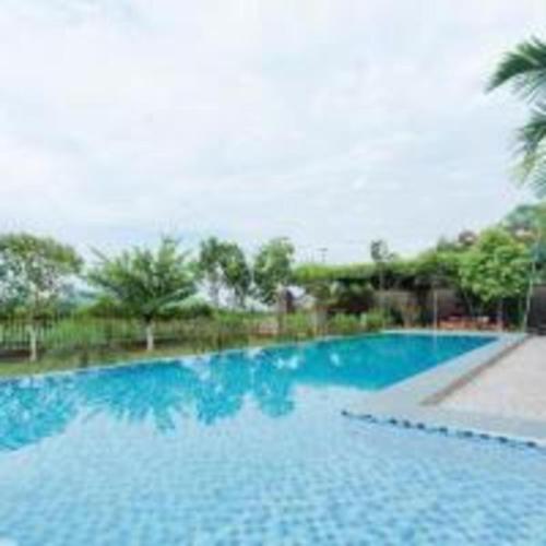 バヴィにあるHương Cỏ Villa Venuestayの木々が茂る青い大型スイミングプール