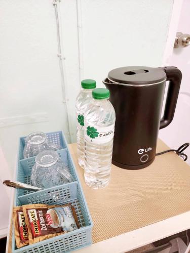a table with a coffee pot and two water bottles at 202-STP Homely room Free Wi-Fi and Near BTS in Sathani Bang Khen
