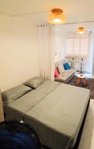 a bedroom with a bed and a couch at Laureles estadio plaza mayor la 70 unicentro in Medellín