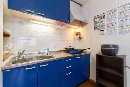 a kitchen with blue cabinets and a sink at 2LDK Quiet area Free parking space 6min from station in Tokyo