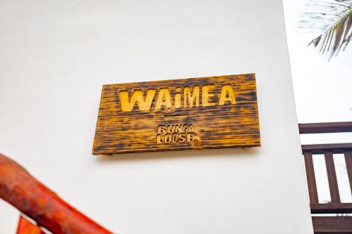 a sign on a wall that says warmite on it at BungaLoose Casa Waimea Oceanfront in Sipacate