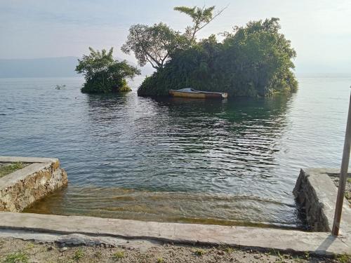 a small island in the water with a boat in it at Matahari Guest House in Tuk Tuk