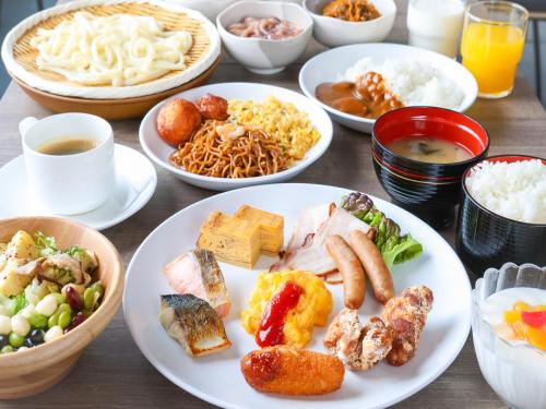 a table with plates of food and bowls of food at APA Hotel Hakodate Ekimae in Hakodate