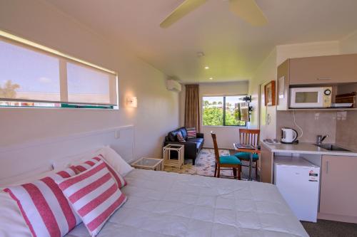 a room with a bed and a kitchen and a kitchen at Blue Marlin Apartments in Whitianga