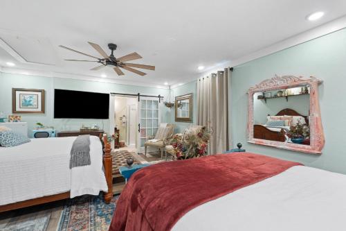 een slaapkamer met een groot bed en een spiegel bij Relaxing Retreat Pool, Spa, Art Studio, Breakfast in Chipley