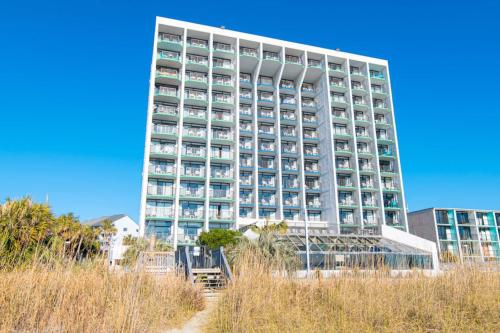 a tall white building with many windows at Oceanfront Pet Friendly Modern Suite in Myrtle Beach