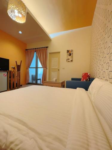a bedroom with a large white bed and a couch at 17 Happiness in Xiaoliuqiu