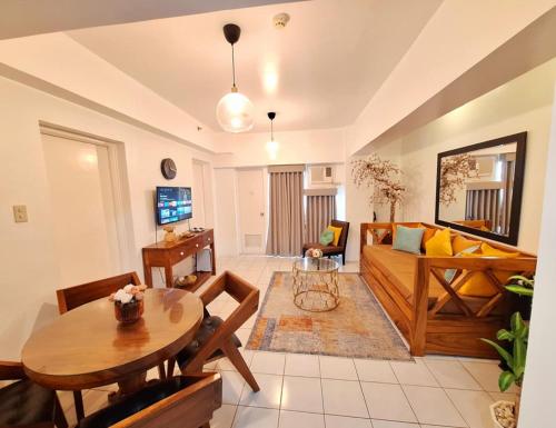 un soggiorno con un divano e un tavolo di 2BR Condo in Tagaytay I Lake View I Fast Wifi I Free Parking a Tagaytay