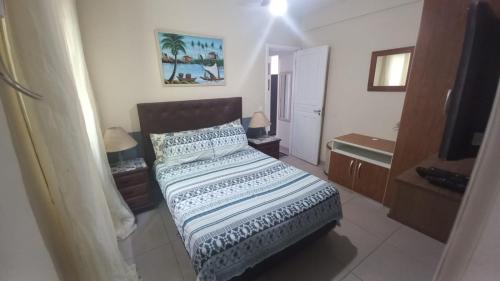 ein Schlafzimmer mit einem Bett und einem Fernseher darin in der Unterkunft Apartamento Porto Real in Mangaratiba