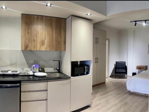 a kitchen with white cabinets and a bed in a room at The magnificence of Zamalek in Cairo