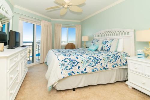 una camera con un letto con copriletto blu e bianco di Rare View Premium Oceanfront 4 BR a Myrtle Beach