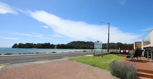 a street sign on the side of a road near the water at Blue Marlin Apartments in Whitianga