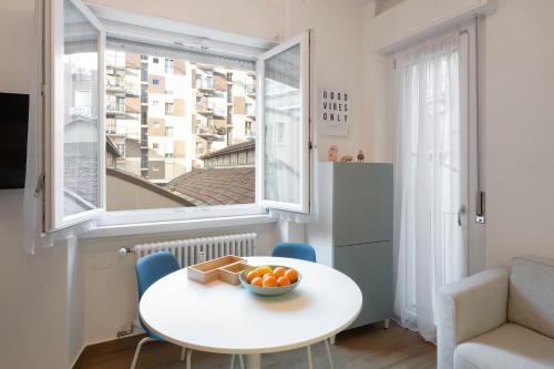 - une petite table et des chaises blanches dans une chambre avec fenêtre dans l'établissement Lomellina 13, à Milan
