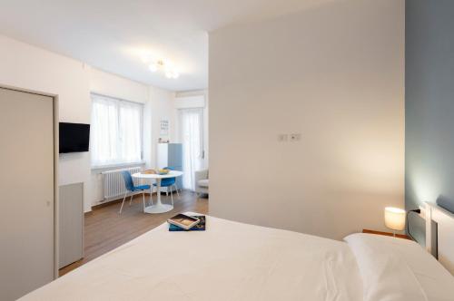 une chambre avec un lit blanc et une table dans l'établissement Lomellina 13, à Milan