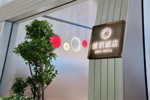 a sign on the side of a building with a tree at JOYA Shanghai Gubei in Shanghai