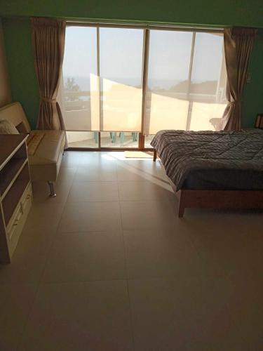 a bedroom with a bed and a large window at Vip Condo Rayong beach in Rayong